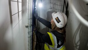 Electrician inspecting cable containment on a UK construction site