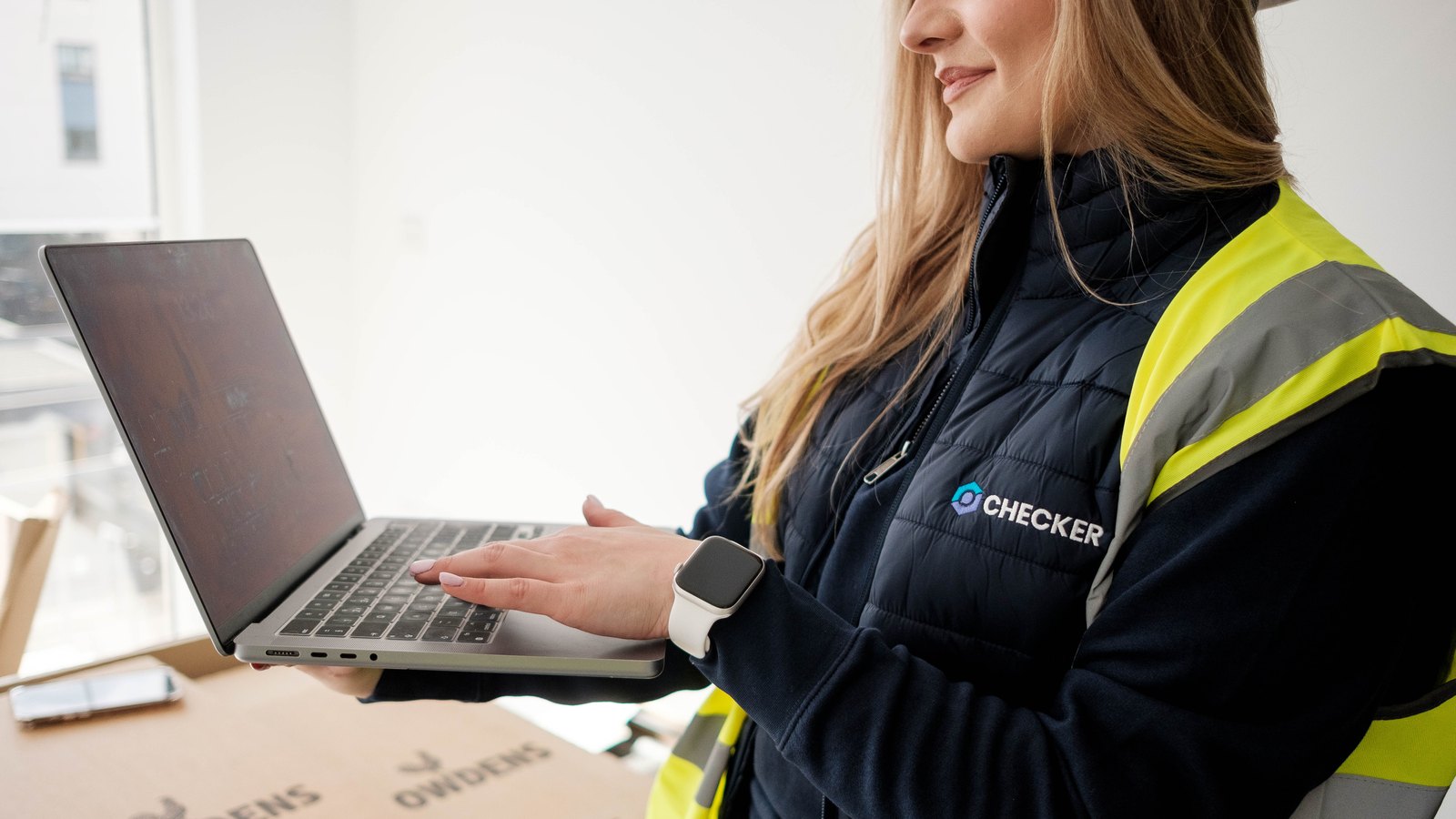 Checker team member using a laptop on site