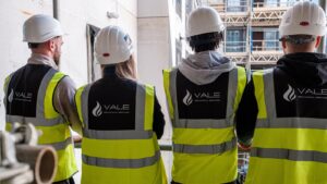 Four tradespeople reviewing a construction site