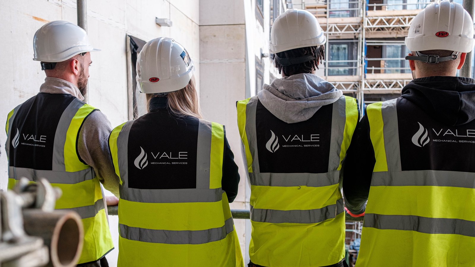 Four tradespeople reviewing a construction site