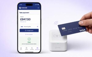 iPhone showing the Checker Take Payment screen with an amount of £847.50 and a green Paid confirmation, next to a white Zettle card reader with a Visa card tapped on top for a contactless payment